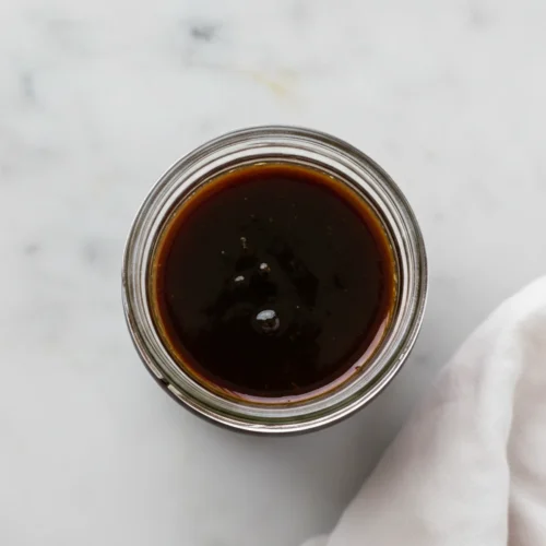 Finished sweet soy glaze (eel sauce) in a plain glass jar.